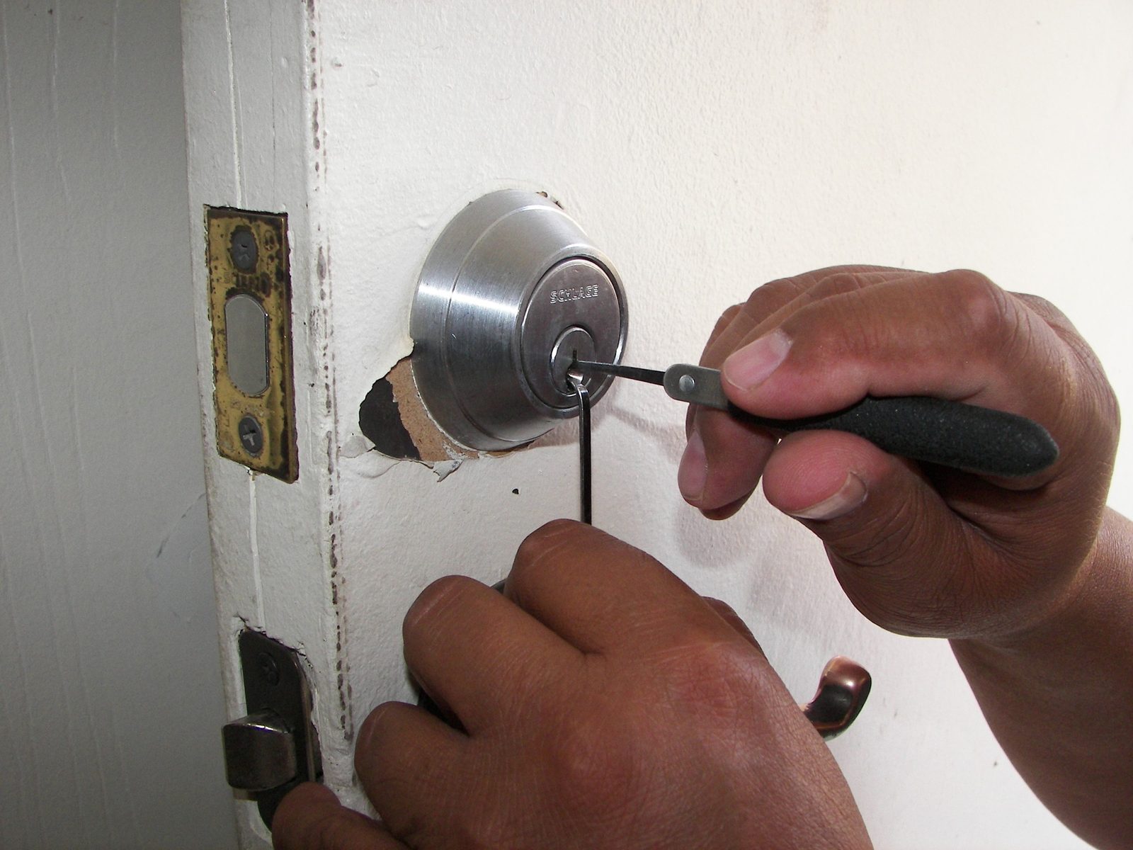 Technicien ouvrant une serrure de porte avec ses outils